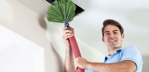 Indoor air quality specialist cleaning air ducts with HVAC duct cleaning machine